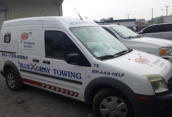 White Blue Gray Towing service van with emergency service lettering