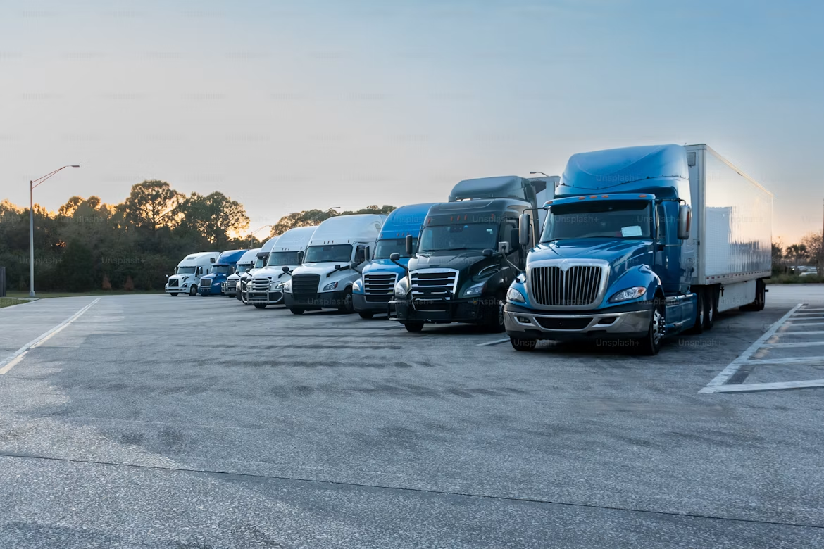 Row of semi trucks parked in a lot at dusk